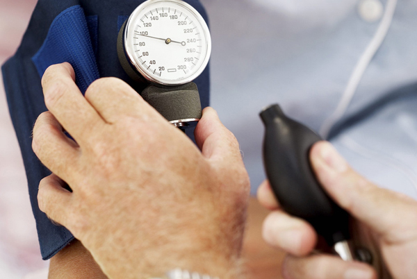 Pair of Human Hands Checking the Blood Pressure of a Patient --- Image by © Royalty-Free/Corbis